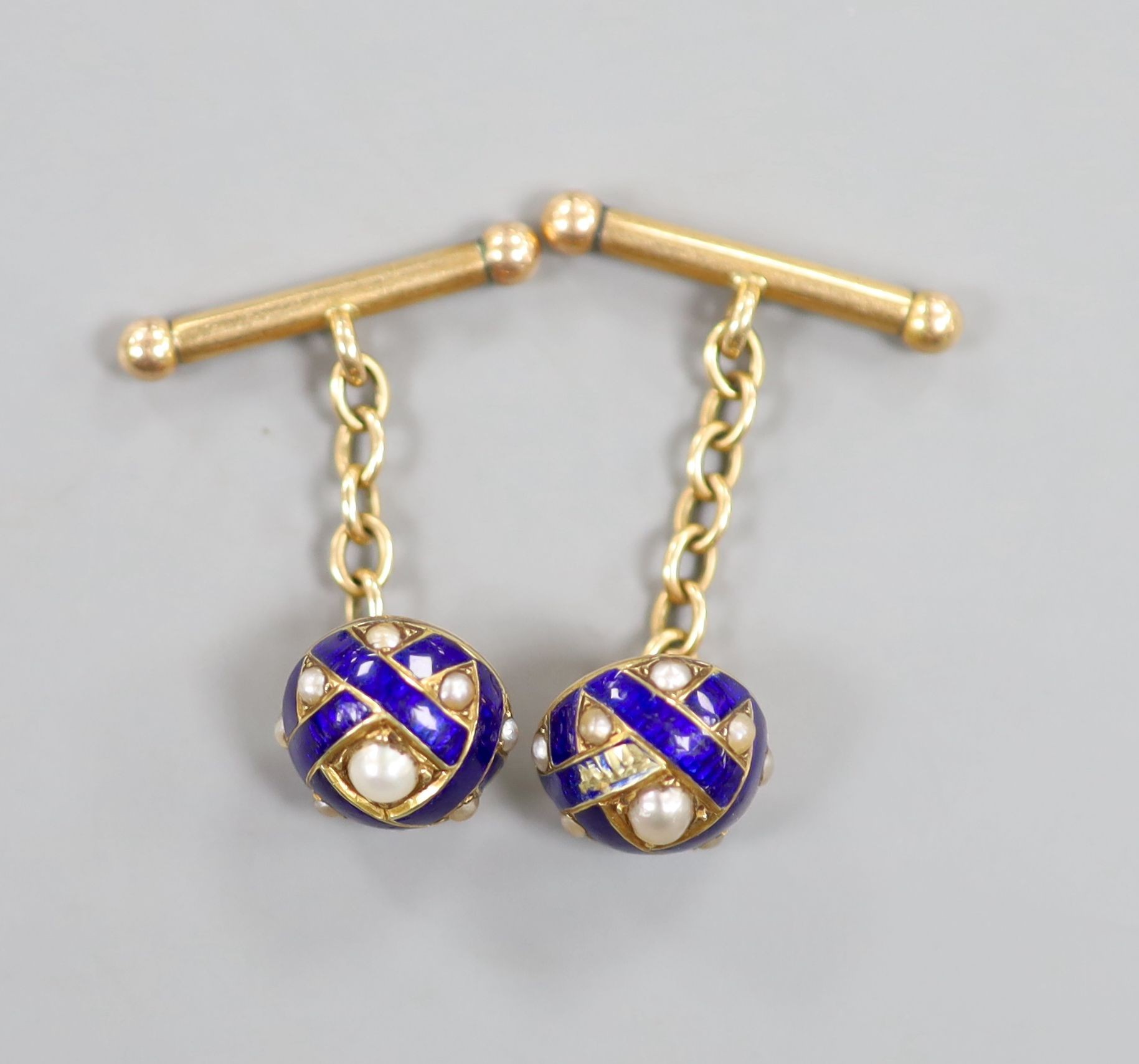 A pair of early 20th century yellow metal, blue enamel and split pearl set domed cufflinks (a.f.), 11mm, gross weight 7.2 grams.
